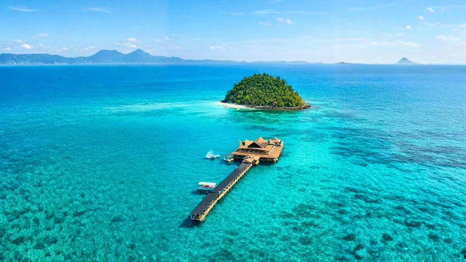 Luftaufnahme der Blue Ocean Bar auf einer kleinen Insel im türkisen Meer vor Port Barton
