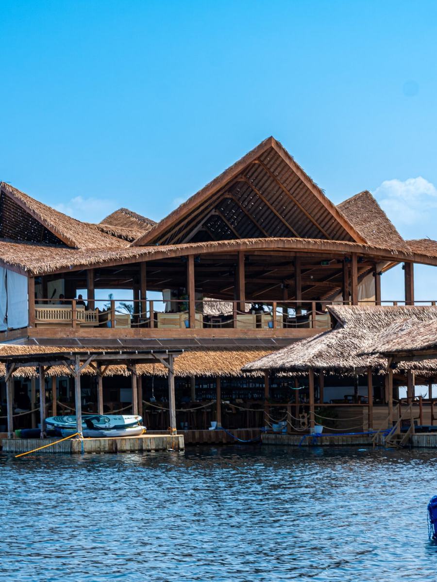 Die Blue Ocean Bar, ein Holzbau mit Strohdach auf dem Wasser vor Port Barton