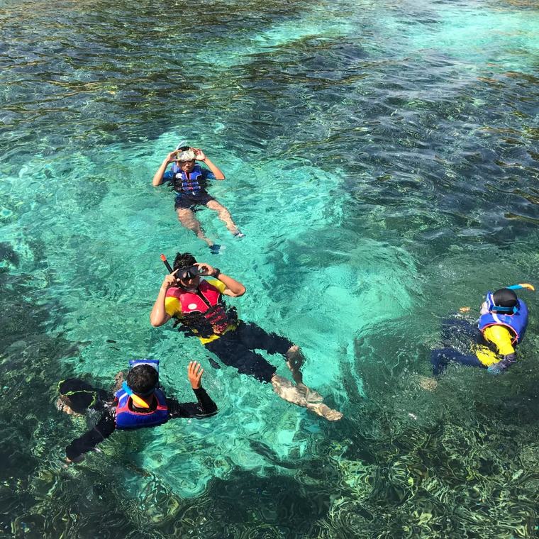 Luftaufnahme von Schnorchlern über dem Riff im türkisen Wasser